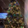 Božićno drvce sa zelenim iglicama, s drvenim ukrasima, s toplom bijelom rasvjetom, u dnevnoj sobi
