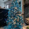 Okićeno božićno drvce s bijelim i srebrnim ukrasima i plavom rasvjetom u dnevnoj sobi