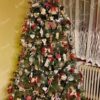 Visoko tamnozeleno umjetno božićno drvce, ukrašeno rustikalnim i drvenim ukrasima