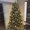 Umjetno božićno drvce sa zelenim granama, ukrašeno zlatno-bakrenim ukrasima