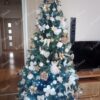 Zeleno umjetno božićno drvce, ukrašeno bijelim i zlatnim ukrasima