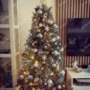 Umjetno božićno drvce s ledenozelenim granama, ukrašeno bijelim i zlatnim ukrasima