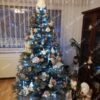 Božićno drvce sa plavim osvjetljenjem i zlatnim pahuljicama