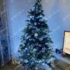 Umjetno božićno drvce s bijelim i zlatnim ukrasima u kutu dnevne sobe