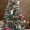Umjetno božićno drvce sa snježnim krajevima grana, ukrašeno šišarkama, crvenim i zlatnim ukrasima