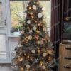 Srebrno umjetno božićno drvce, ukrašeno šišarkama i prirodnim ukrasima