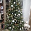 Božično drvce sa zelenim iglicama ukrašeno zlatno-bijelim kuglicama i Djedom Božićnjakom