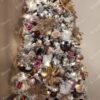Ukrašeno snježno umjetno božićno drvce sa zlatnim ukrasima