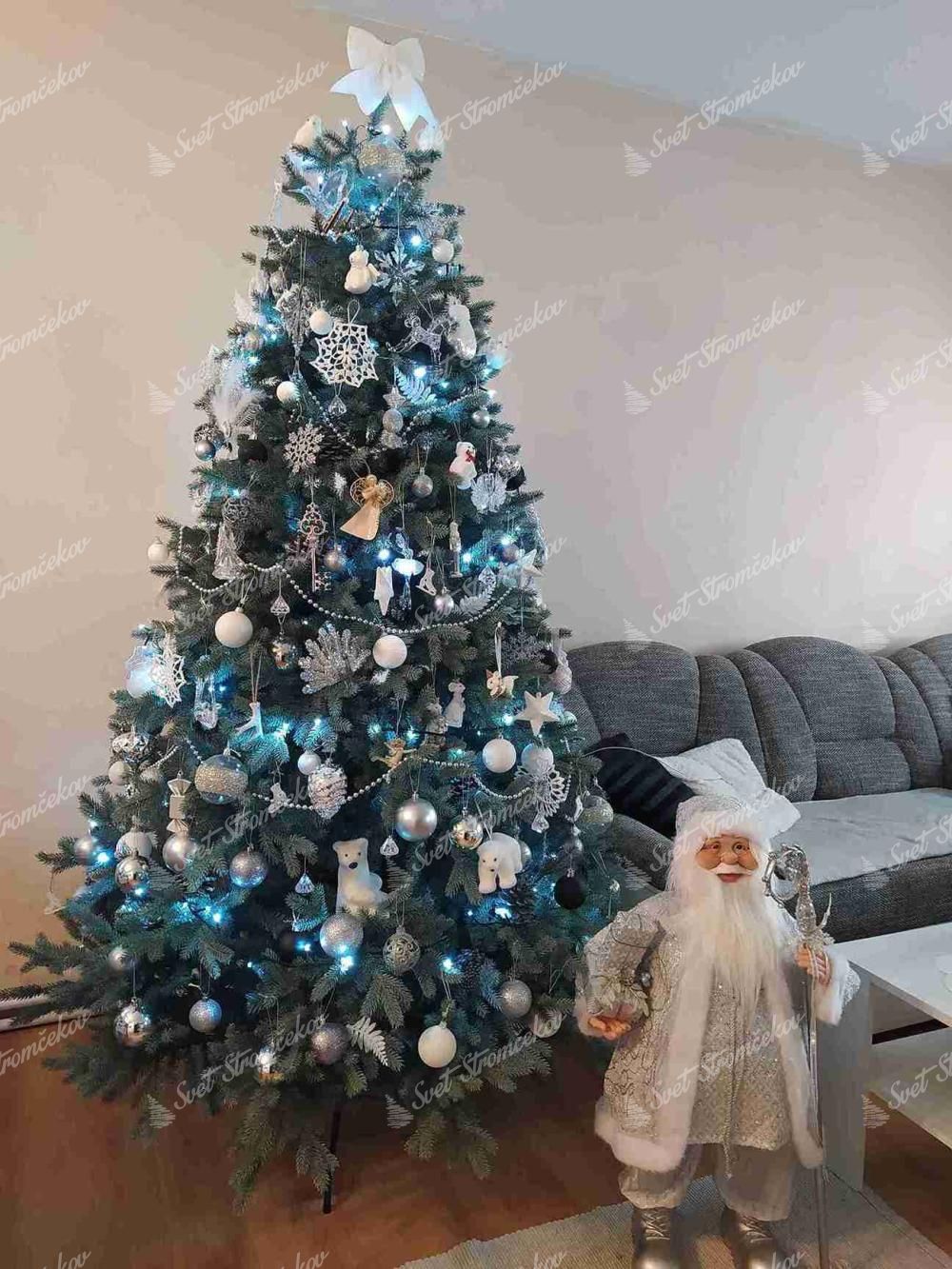 Umelý vianočný stromček 3D Smrek Ľadový 210cm, stromček má husté zeleno strieborné ihličie a je ozdobený bielymi a modrými ozdobami