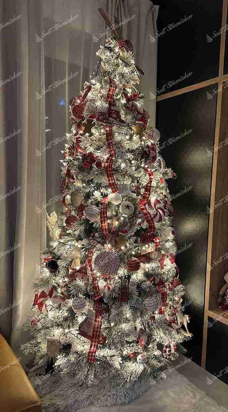 Umelý vianočný stromček Borovica Biela Úzka 225cm, stromček je husto zasnežený a je ozdobený červenými a bielymi ozdobami